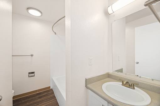 A bathroom with a sink, mirror, and toilet.