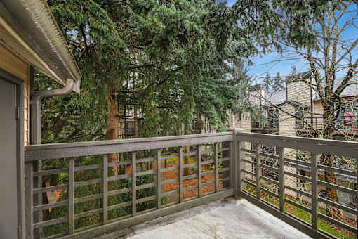 A balcony with a railing and snow on the ground.