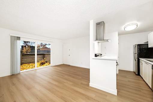 A kitchen with a white counter and wooden floors.