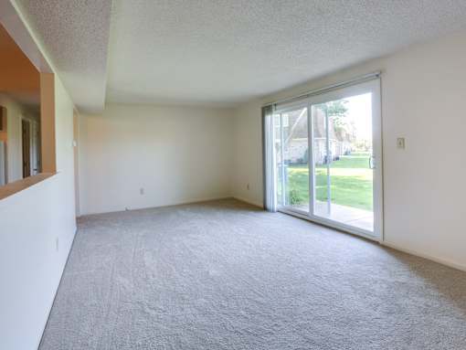 an empty living room with a sliding glass door