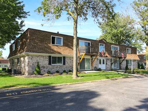 the front of a brick house with an flag on the porch
