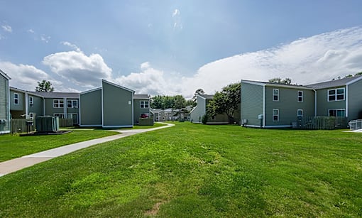 A row of houses with green lawns in front.