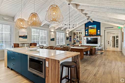 A kitchen with a blue wall and wooden floors.
