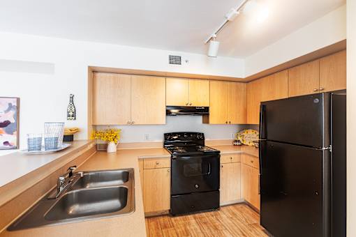 a kitchen with black appliances and wooden cabinets