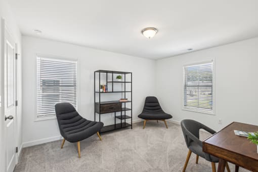 two chairs and a table in a room with two windows