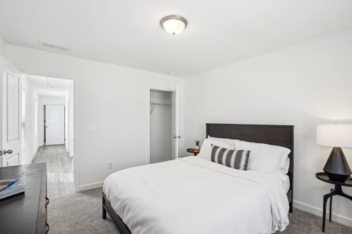 a bedroom with a large white bed and a dark wooden headboard