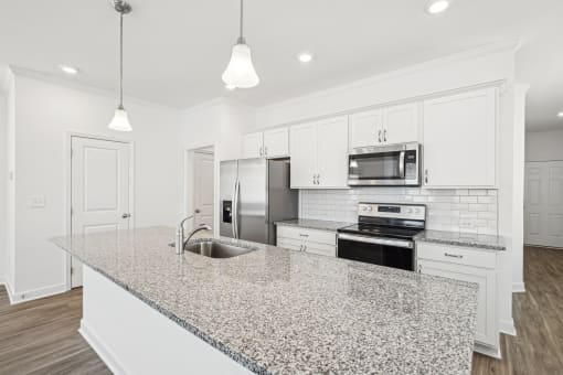 a kitchen with white cabinets and a granite counter top