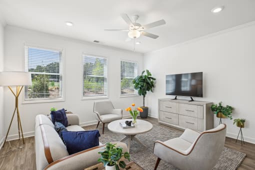 a living room with couches and chairs and a tv
