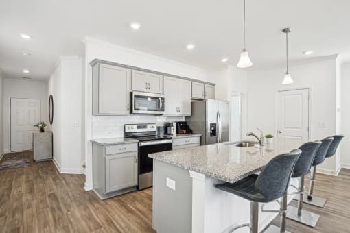 a kitchen with white cabinets and a marble counter top