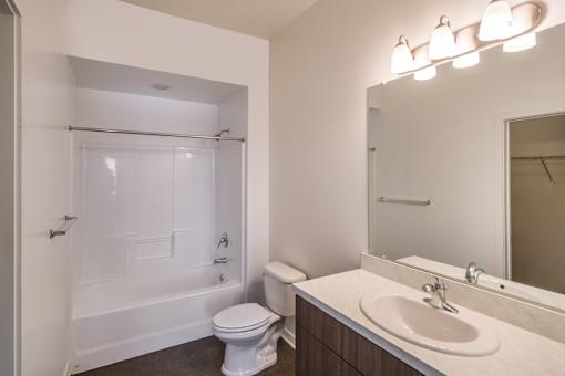 A white toilet sits next to a sink in a bathroom.