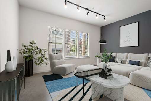 A living room with a white couch, a coffee table, and a plant.