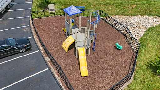 A playground with a yellow slide and a blue roofed structure.