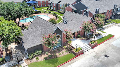 A bird's eye view of a residential area with houses and a swimming pool.