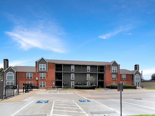 A large brick building with a parking lot in front.