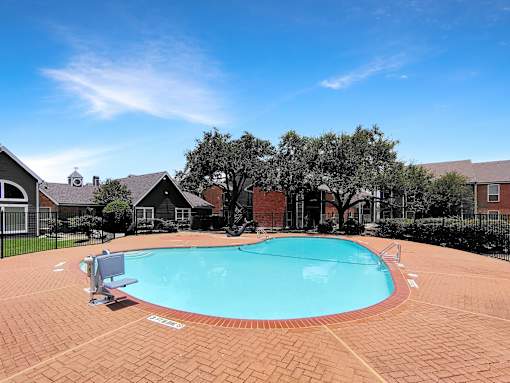 A small pool surrounded by a brick patio.