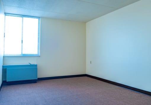 an empty room with a desk and a window
