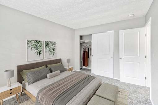 A bedroom with a bed, nightstand, and two framed pictures on the wall.
