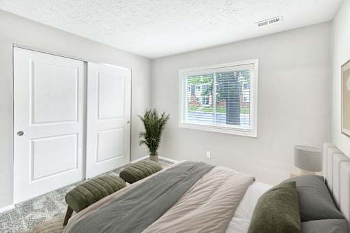 A bedroom with a large bed and a window showing an outdoor view.