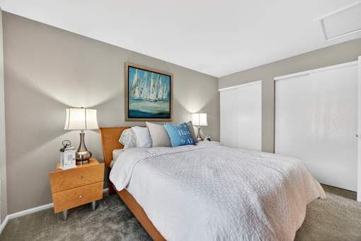 A bedroom with a large bed and a painting on the wall.