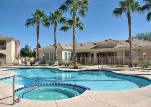 a swimming pool with palm trees in front of a house