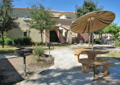a patio with a table and a umbrella in front of a building