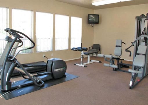 a gym with exercise equipment and a tv