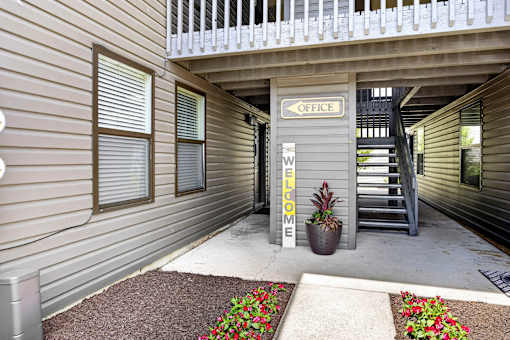 A small courtyard with a sign that says "Office" and "Welcome".