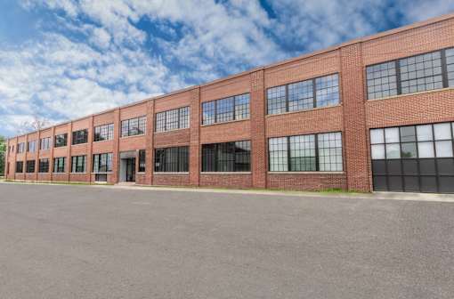 A long brick building with many windows and doors.