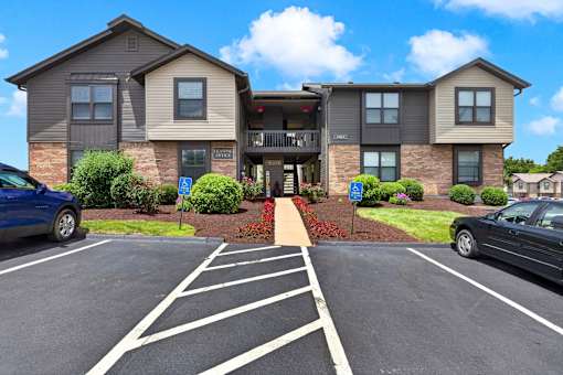 A parking lot in front of a two-story apartment building.