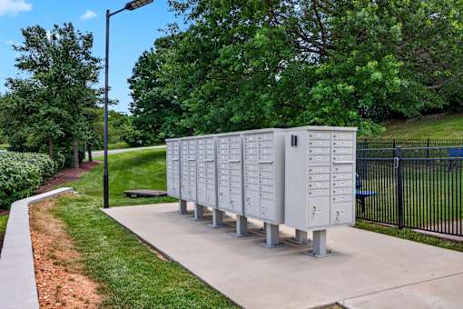 A row of mailboxes are lined up on a sidewalk.