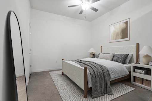A bedroom with a bed, nightstand, and a painting on the wall.