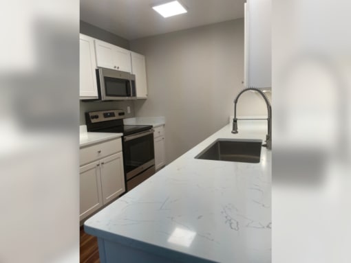 a kitchen with white cabinets and a white counter top