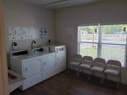A laundry room with washers and dryers and a sign on the wall.