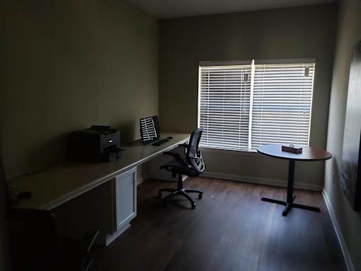 A room with a desk, chair, and a computer monitor.