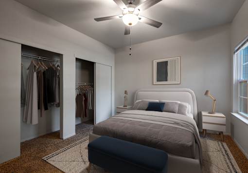 A bedroom with a bed, a dresser, and a ceiling fan.