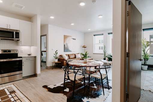 A modern kitchen with a dining table set for four.
