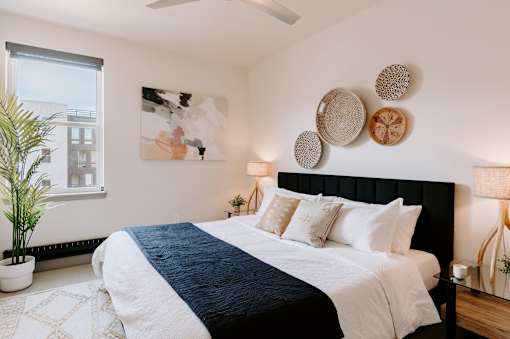 A bedroom with a large bed and a plant.