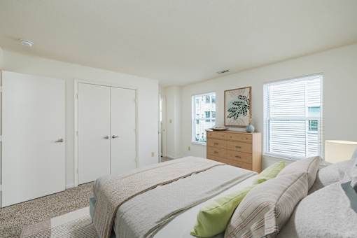 A bedroom with a bed, dresser, and wardrobe.