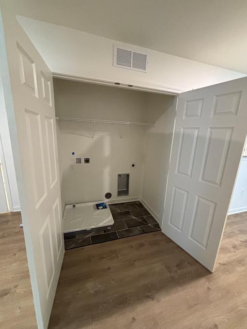 A white refrigerator is installed in a room with wooden walls.