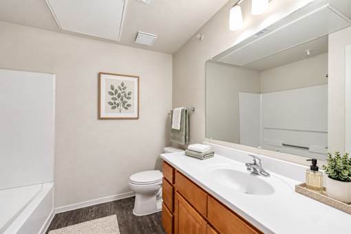 A bathroom with a toilet, sink, and mirror.