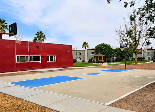 A basketball court with a red wall and a basketball hoop.