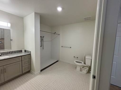 A bathroom with a toilet, sink, and shower.