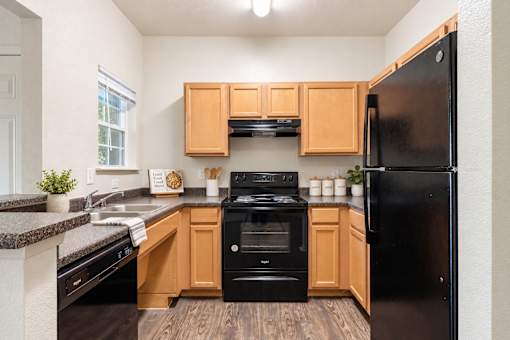 A kitchen with black appliances and wooden cabinets.
