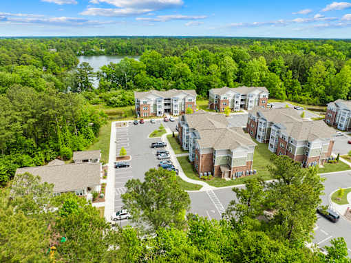 A bird's eye view of a residential area with a parking lot and buildings.