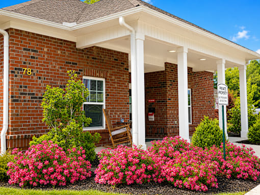 A brick house with a porch and a sign that says "Front Porch".