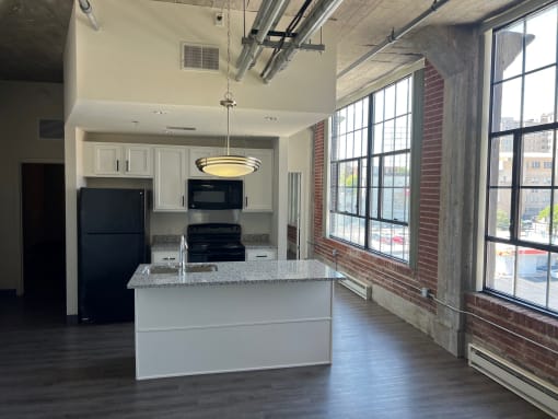 an open kitchen with a large window and a counter top in front of a kitchen