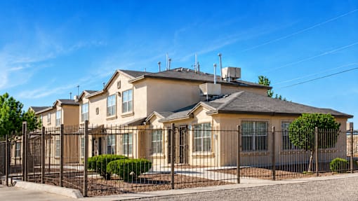 A row of houses with a black fence in front.