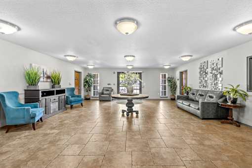 A spacious living room with a variety of furniture and plants.
