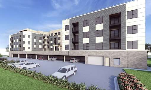 A modern apartment building with a parking lot in front.