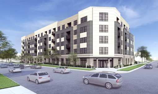 A modern apartment building with cars parked in front.